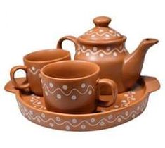 the tea set is brown and has three cups on it, one with a saucer