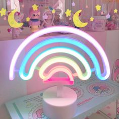 a rainbow shaped light sitting on top of a table next to other toys and decorations