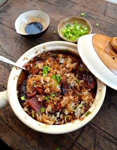 a bowl filled with food sitting on top of a wooden table next to other bowls