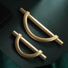 two brass door handles on a green cloth