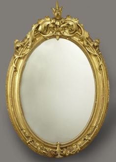 an ornate gold framed mirror against a gray background