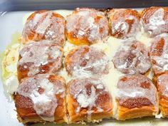 a pan filled with cinnamon rolls covered in icing