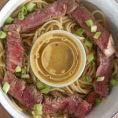 a bowl filled with noodles, meat and sauce