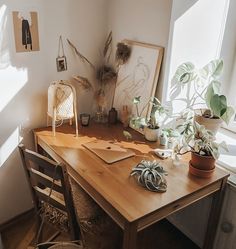 a wooden desk topped with plants next to a window