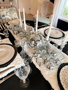 a black table topped with lots of dishes and silverware covered in disco ball decorations