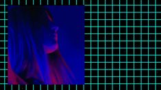 a woman with long hair standing in front of a blue and purple grid wallpaper