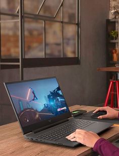 a person using a laptop on a wooden table