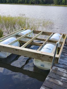 two kayaks are tied up on the dock by the water's edge and ready to go into the lake