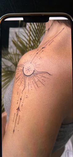 a woman's arm with the sun and stars tattoo on her left side shoulder