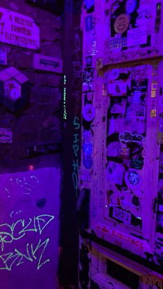 graffiti on the walls and door of a building with purple light coming from behind it