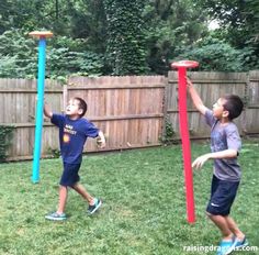 two young boys playing with an inflatable ball and hoop set outside on the grass