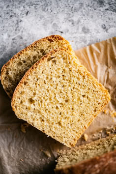 two slices of bread sitting on top of a piece of wax paper