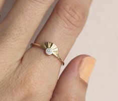 a woman's hand with a gold ring and diamond on the middle of her finger