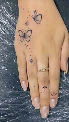 a woman's hand with two butterflies on her left and one butterfly on the right