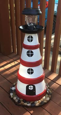 a white and red cone shaped lamp on a wooden deck