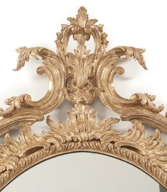 an ornate gold framed mirror against a white wall