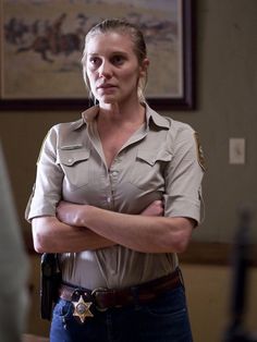 a woman in uniform standing with her arms crossed