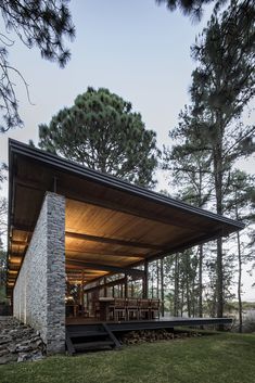 the house is surrounded by trees and has a stone wall that wraps it's sides