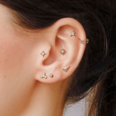 a close up of a person's ear with three different piercings on it