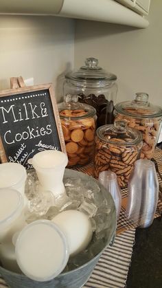 there are cookies and milk in the bowl on the counter next to glass jars with white lids