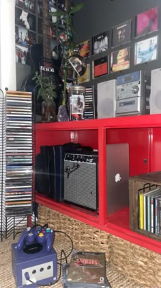 a red entertainment center in a living room filled with musical instruments and bookshelves