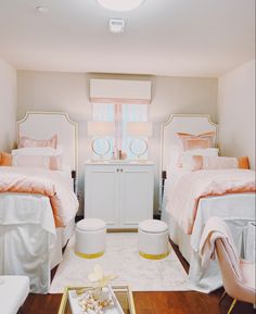 two twin beds in a bedroom with white furniture and orange accents on the bedding