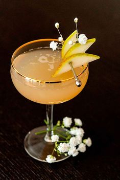 an apple martini garnished with white flowers