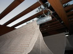 a close up of a piece of cloth hanging from a metal rod on a wooden structure