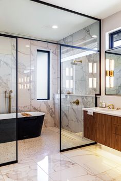 a bathroom with marble walls and flooring next to a bathtub in the corner