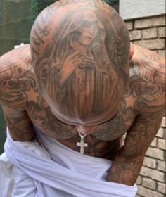 a man with tattoos covering his face and back