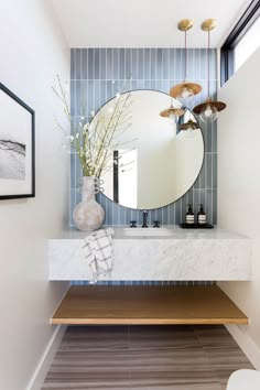 a bathroom sink with a mirror and vase on top of it next to a counter