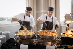 two men in aprons cooking food on top of a stove