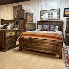 a bed room with a neatly made bed and wooden furniture on the floor next to a wall