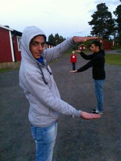 two people standing in the middle of an empty lot with one person holding out his hand