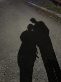 the shadow of two people standing next to each other