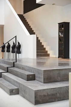 the stairs are made of concrete and have black sculptures on each step in front of them