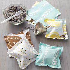 four napkins with different designs on them sitting next to a bowl of food and spoon