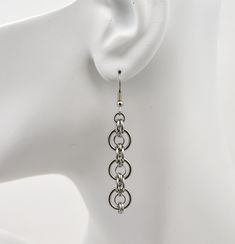 With its sleek curves, these earrings are modern and versatile. Multiple stainless steel ring sizes are used to create a ring-within-a-ring pattern. Earrings are approximately 2.5" long from top of earwire. Stainless Steel Wire Jewelry, Piercing Reference, Chain Mail Earrings, Egyptian Inspired Jewelry, Chainmaille Jewelry Patterns, Chainmaille Jewelry, Ring Pattern, Earring Hoop, Multiple Rings