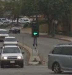 a green traffic light sitting above a street filled with cars