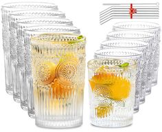 several glasses with different types of drinks in them and one is filled with orange juice