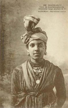 an old black and white photo of a woman wearing a turban, headdress, and jewelry