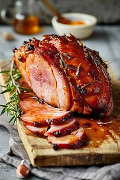 sliced ham on a cutting board with herbs