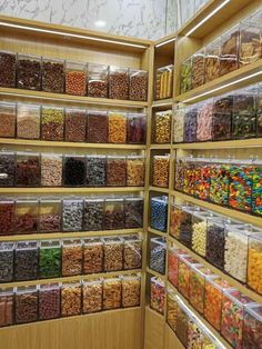 the shelves are filled with many different types of candies and cereals in plastic containers