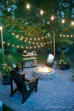 an outdoor fire pit with lights strung over it