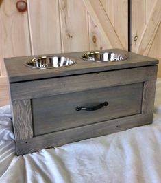 a wooden box with two bowls on it