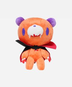 an orange stuffed animal with purple eyes and fangs on it's face, sitting in front of a white background