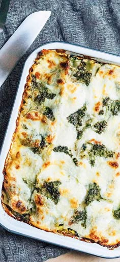 a casserole dish with broccoli and cheese in it on a table