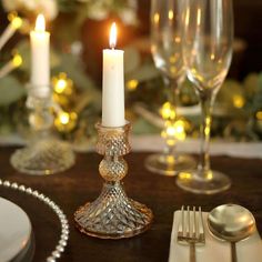 a candle is lit on a table with silverware