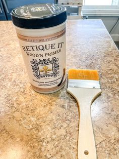 a paint brush sitting on top of a counter next to a can of wood primer