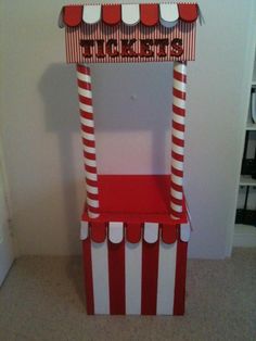 a red and white striped chair with a ticket booth